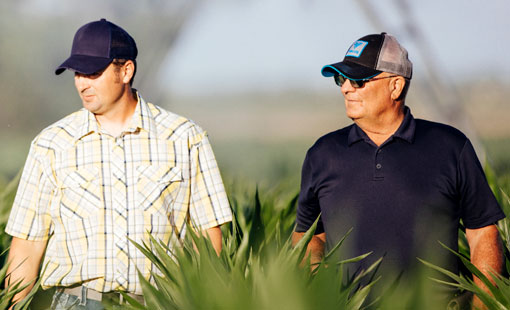 Two men standing in a field.