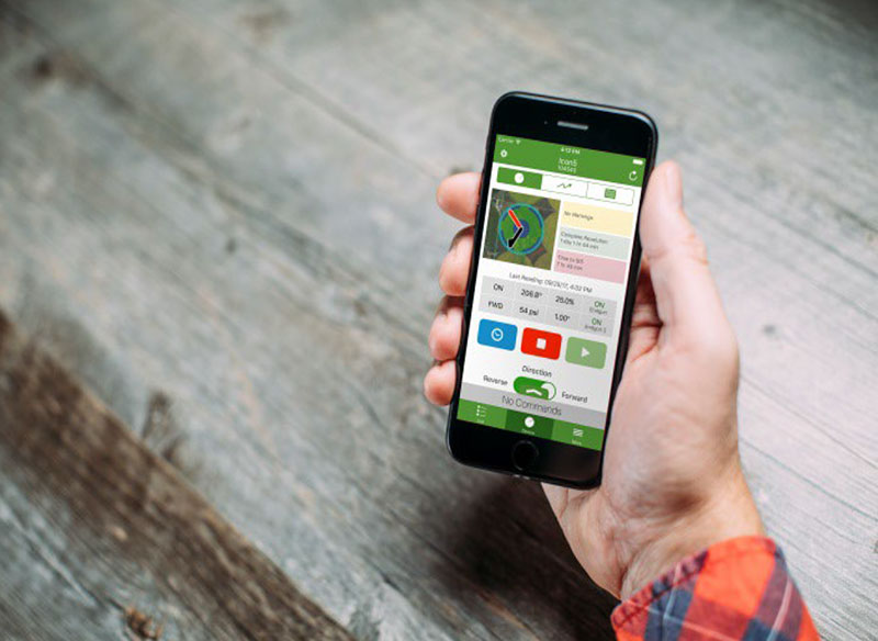 Farmer monitoring his phone and checking on his farm.