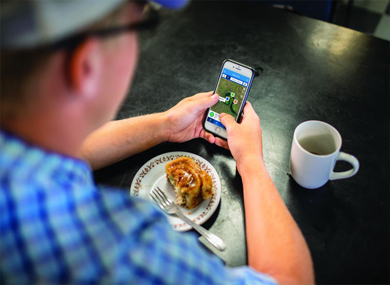 Farmer checking his farm while eating a meal.